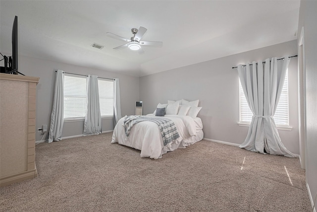 carpeted bedroom featuring baseboards, a ceiling fan, and visible vents
