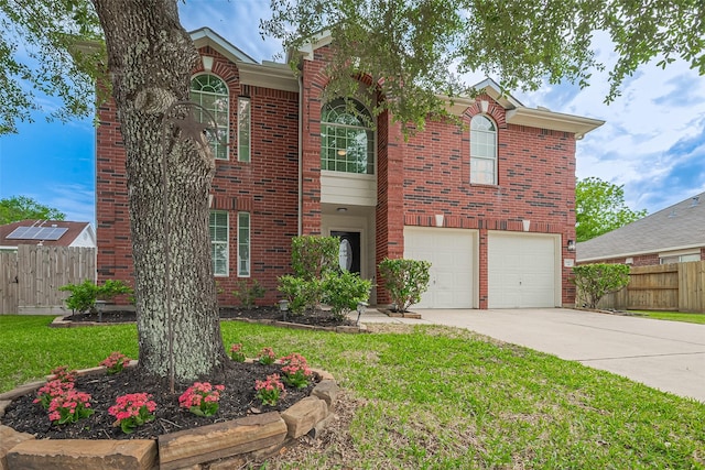 traditional-style house featuring fence, driveway, brick siding, and a garage