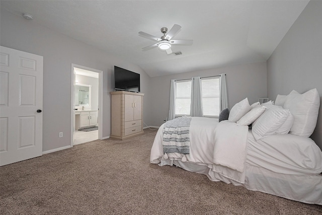 bedroom featuring visible vents, baseboards, connected bathroom, light carpet, and lofted ceiling