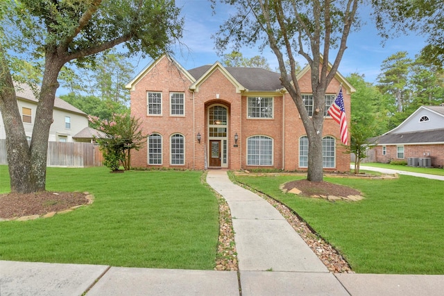 14010 Lakewood Crossing Blvd, Houston, TX 77070 - traditional-style home featuring brick siding, fence, central AC unit, and a front lawn