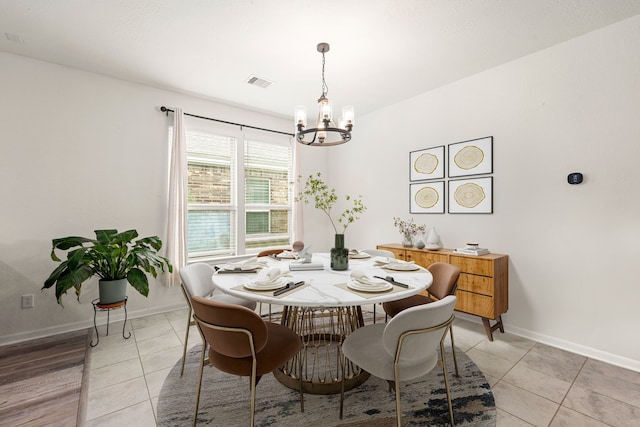 dining room with visible vents, baseboards, light tile patterned flooring, and a chandelier