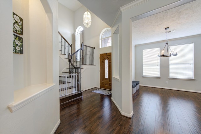 entrance foyer featuring visible vents, baseboards, stairway, dark wood-type flooring, and a notable chandelier
