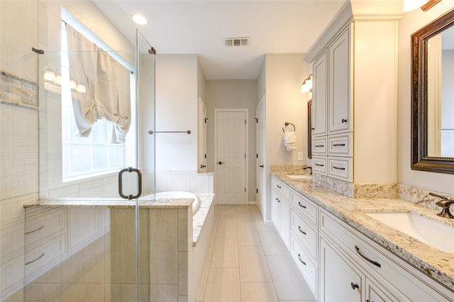 full bath featuring double vanity, a garden tub, visible vents, a stall shower, and tile patterned floors