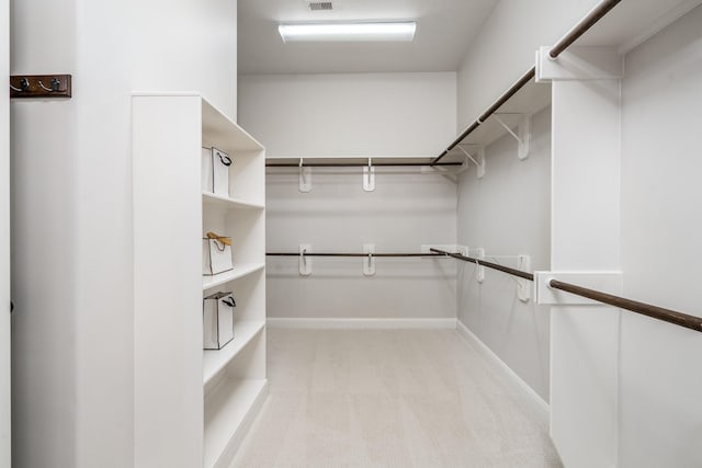 spacious closet featuring light colored carpet and visible vents