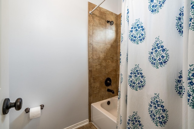 bathroom with baseboards and shower / bath combo with shower curtain