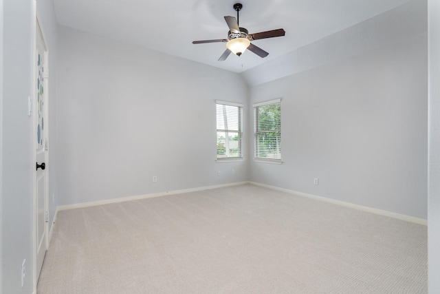 spare room featuring baseboards, a ceiling fan, and light colored carpet
