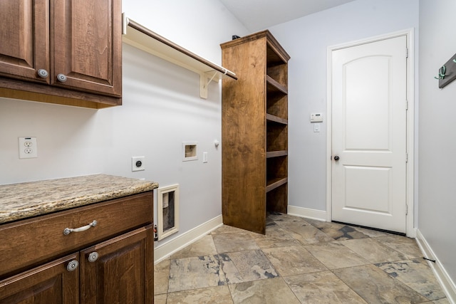 laundry area with cabinet space, hookup for a washing machine, stone finish floor, electric dryer hookup, and baseboards