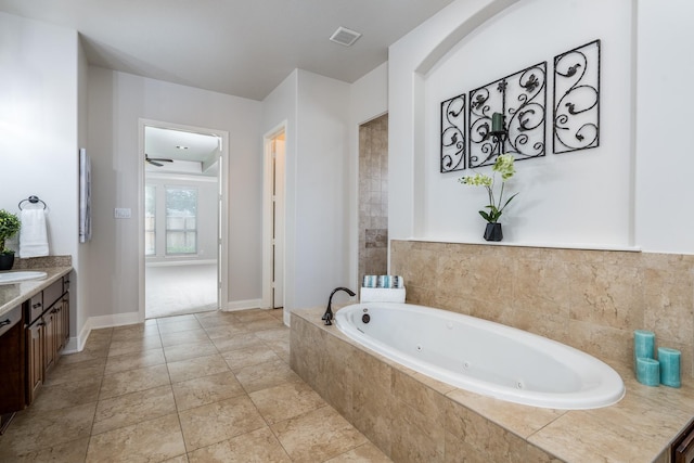 full bath with a jetted tub, vanity, ceiling fan, and visible vents