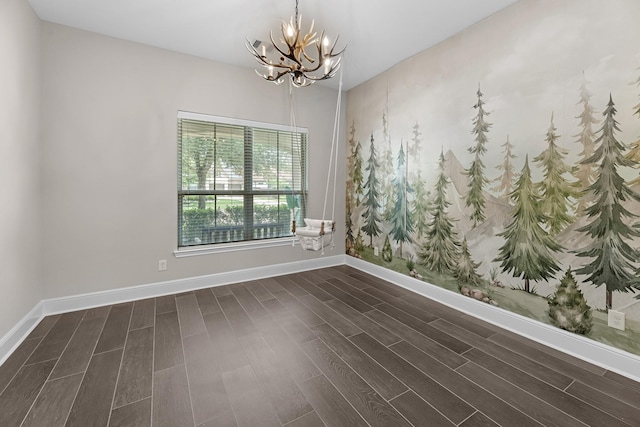 spare room with an inviting chandelier, baseboards, and dark wood-type flooring
