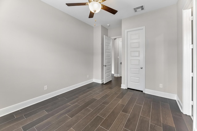 unfurnished bedroom featuring baseboards, a ceiling fan, dark wood-style floors, and visible vents