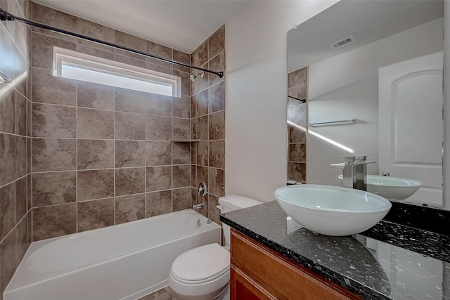 bathroom featuring vanity, toilet, visible vents, and bathtub / shower combination