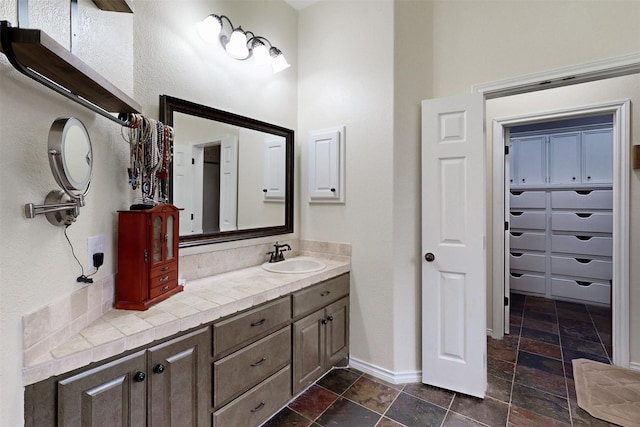 7576 River Ridge Drive, College Station, TX 77845 - bathroom with baseboards, stone tile floors, and vanity