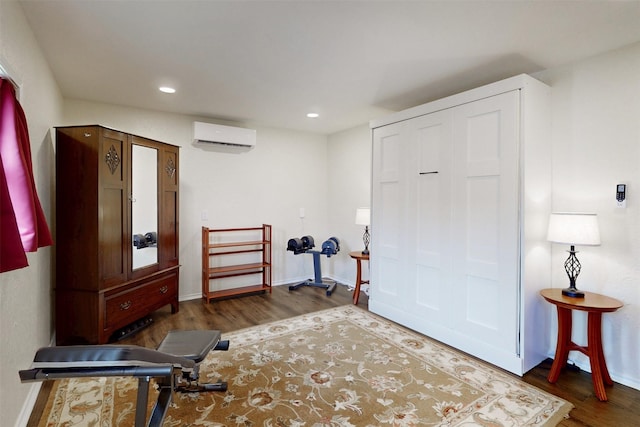 7576 River Ridge Drive, College Station, TX 77845 - workout area with an AC wall unit, recessed lighting, baseboards, and wood finished floors