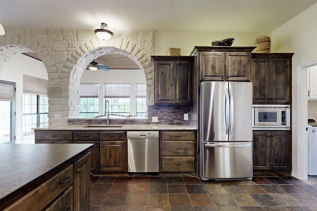 7576 River Ridge Drive, College Station, TX 77845 - kitchen with a sink, appliances with stainless steel finishes, dark brown cabinetry, and stone tile floors