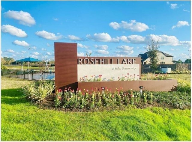 community sign featuring a yard and fence