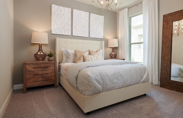 carpeted bedroom with baseboards and a notable chandelier