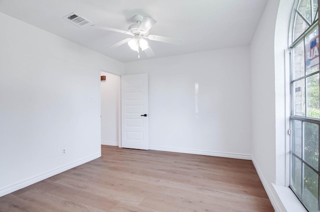 unfurnished room featuring visible vents, a ceiling fan, baseboards, and wood finished floors