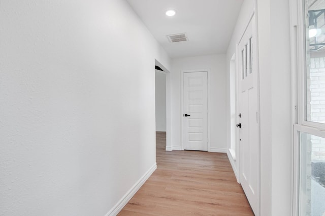 hallway with light wood-style floors, baseboards, recessed lighting, and visible vents