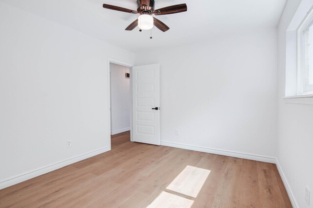 empty room with light wood-style floors, baseboards, and ceiling fan
