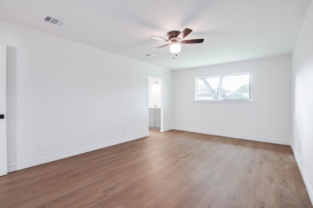 spare room featuring visible vents, light wood-style floors, and ceiling fan