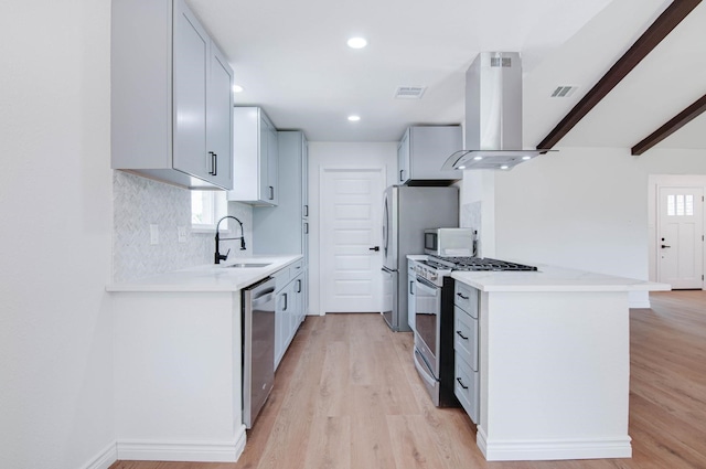kitchen featuring appliances with stainless steel finishes, a sink, light wood-style flooring, island exhaust hood, and visible vents