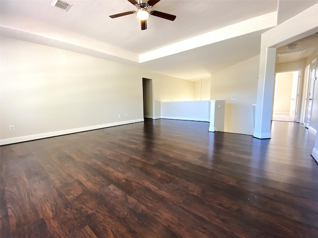 unfurnished room featuring baseboards, ceiling fan, dark wood finished floors, and visible vents