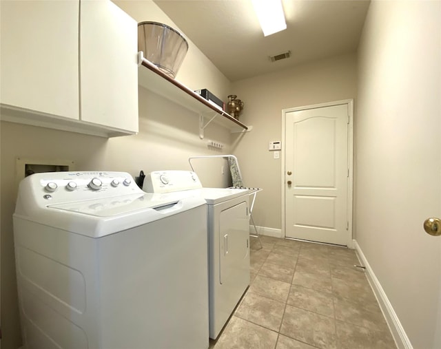 laundry area featuring cabinet space, washing machine and clothes dryer, visible vents, and baseboards