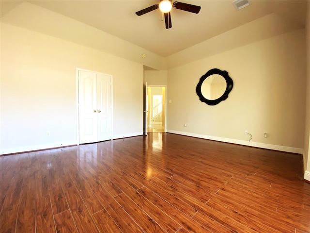 empty room with visible vents, dark wood-style flooring, baseboards, and ceiling fan
