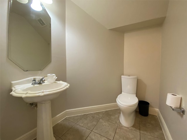 half bath featuring toilet, baseboards, and tile patterned floors