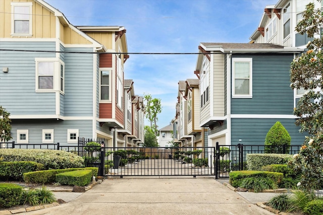 view of road featuring a residential view, a gate, and driveway