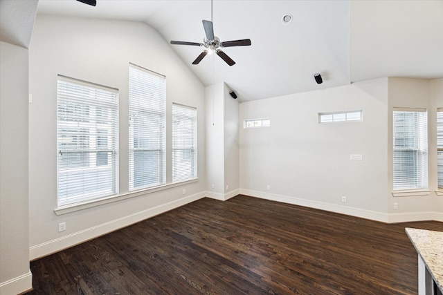 unfurnished room featuring a ceiling fan, dark wood-style flooring, vaulted ceiling, and a wealth of natural light