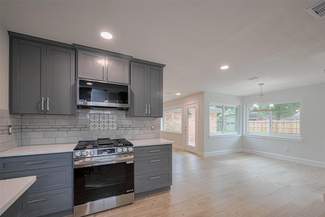 kitchen featuring baseboards, appliances with stainless steel finishes, visible vents, and gray cabinetry