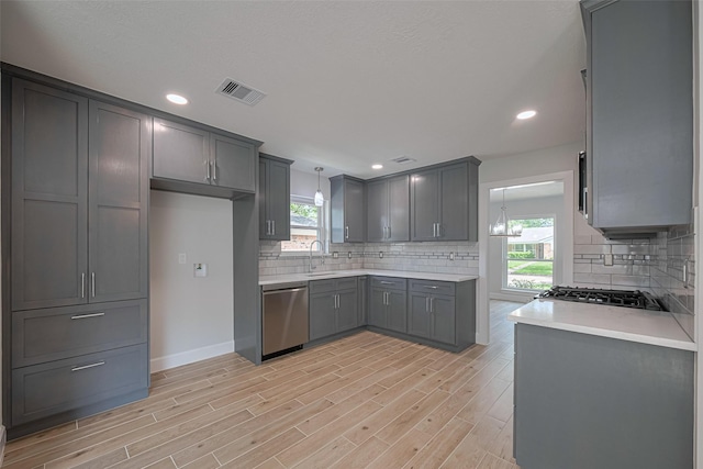 kitchen featuring light wood-style floors, a sink, dishwasher, and a wealth of natural light