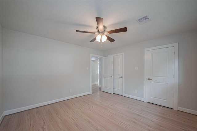 unfurnished bedroom featuring baseboards, ceiling fan, light wood-type flooring, and visible vents