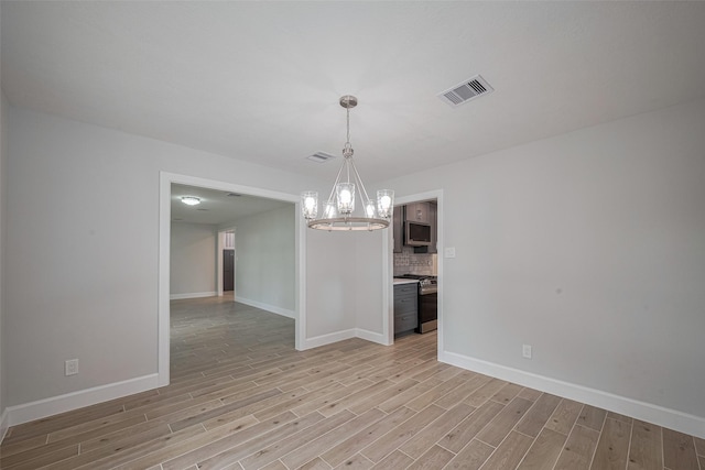 unfurnished dining area with a chandelier, baseboards, visible vents, and light wood-style flooring