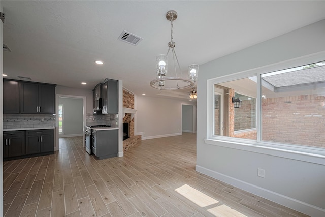 kitchen with visible vents, an inviting chandelier, baseboards, light countertops, and tasteful backsplash