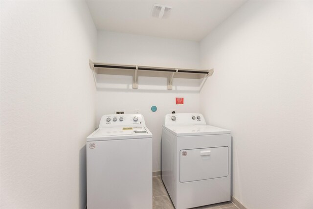 3907 Itzle Island Ct, Katy, TX 77494 - clothes washing area with laundry area, visible vents, washing machine and clothes dryer, baseboards, and light tile patterned flooring