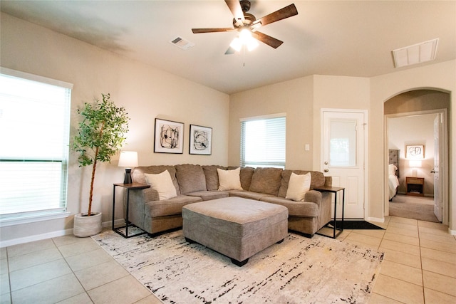 living room featuring arched walkways, visible vents, and light tile patterned flooring