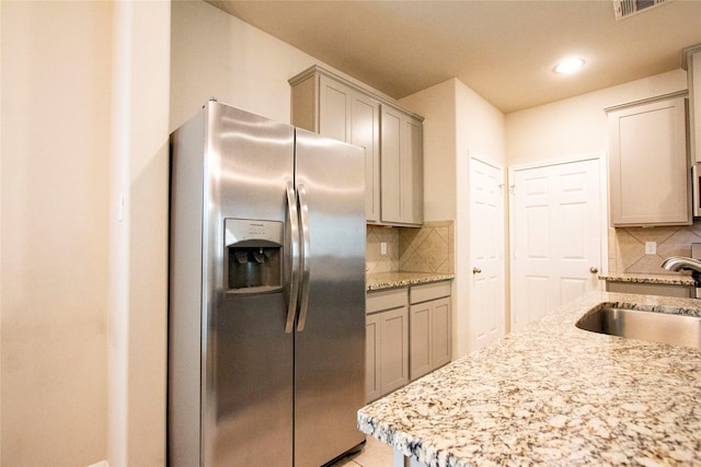 kitchen featuring backsplash, appliances with stainless steel finishes, a sink, and visible vents