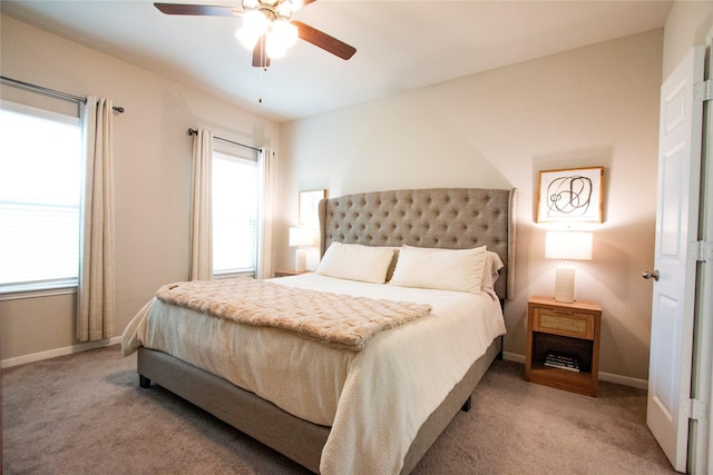 bedroom featuring baseboards, multiple windows, and carpet