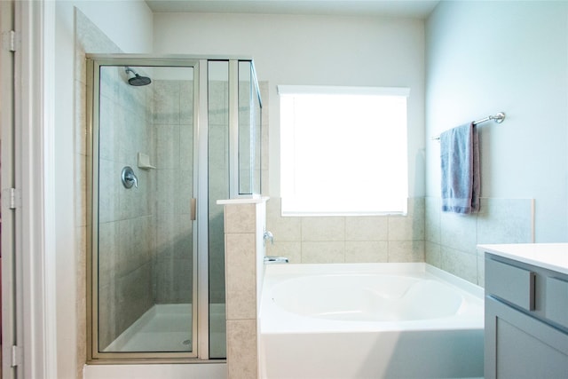 bathroom with vanity, a shower stall, and a bath