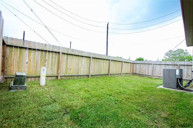 view of yard with central air condition unit and a fenced backyard