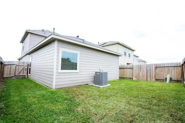 back of property featuring a fenced backyard, a yard, and cooling unit