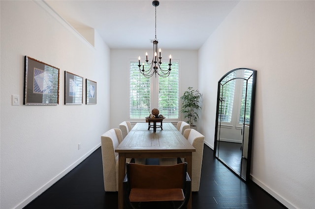 dining space with baseboards, an inviting chandelier, and dark wood finished floors