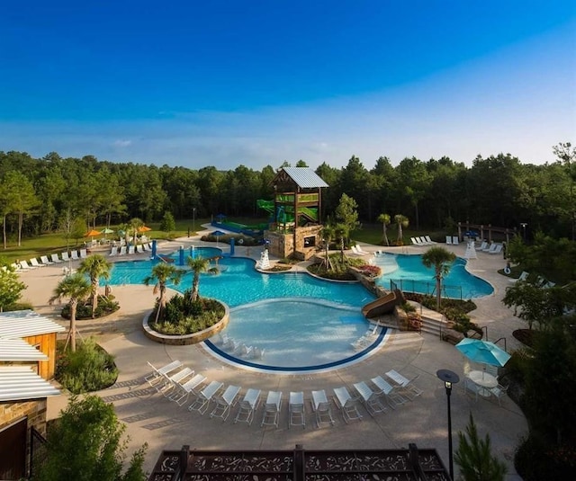community pool featuring a patio and a forest view