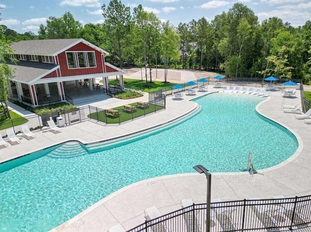 community pool with a patio and fence