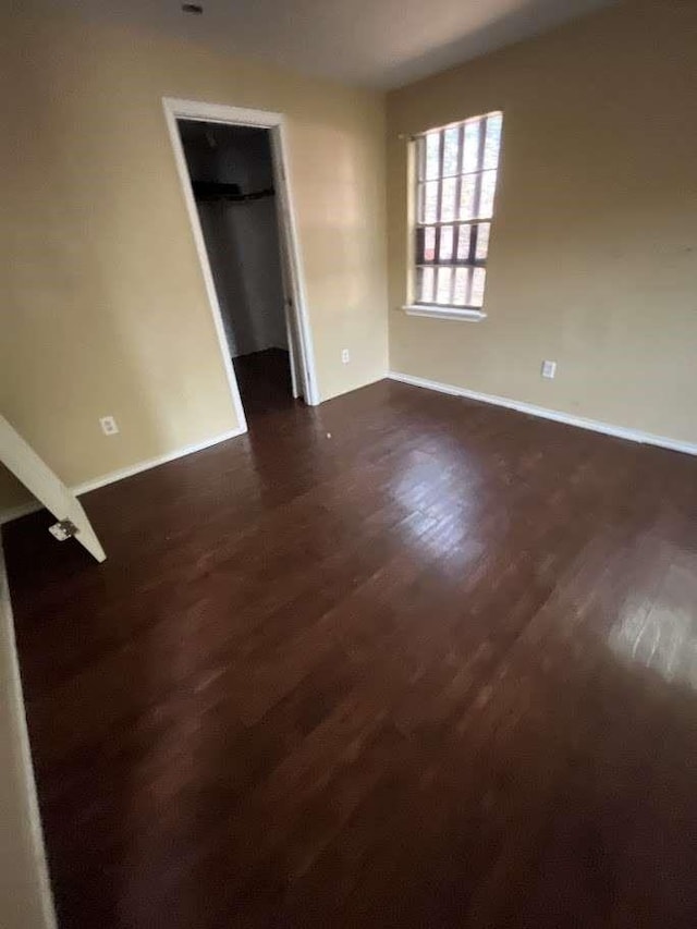 interior space featuring baseboards and dark wood-type flooring