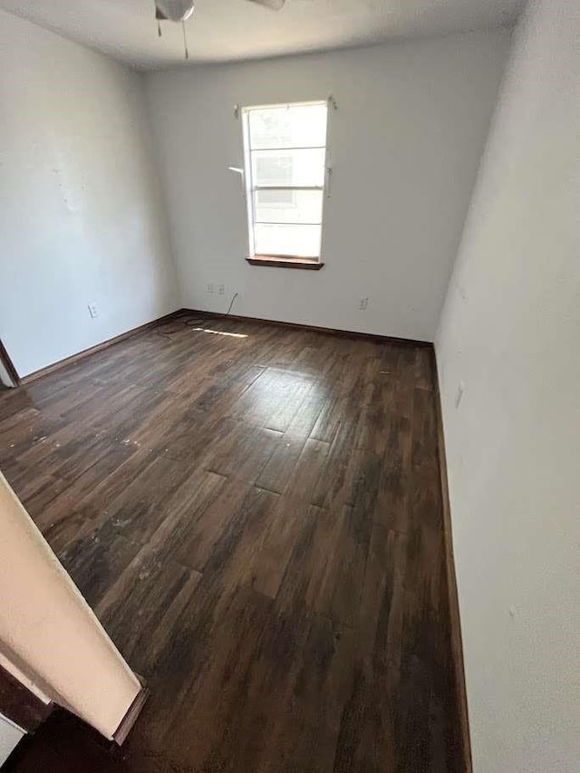 empty room with baseboards and wood finished floors