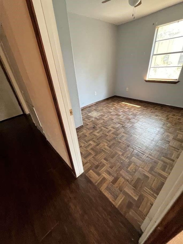 spare room with baseboards and ceiling fan