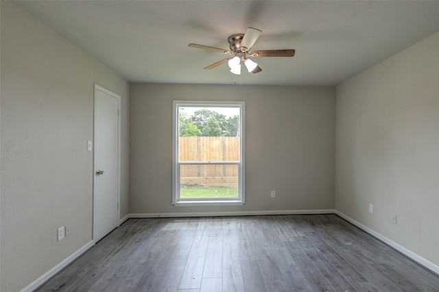 empty room featuring baseboards, ceiling fan, and wood finished floors